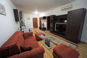 a living room with a couch and a television at Apartments in hotel Primorsko Del Sol in Primorsko +1 photo