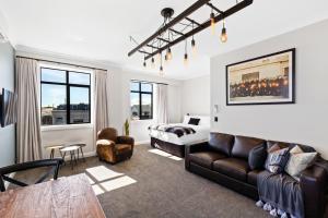 a living room with a couch and a bed at Hokitika Fire Station Boutique Accommodation in Hokitika