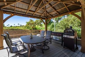 a patio with a table and chairs and a stove at Noahs Hideaway Luxury B&B in Lahaina