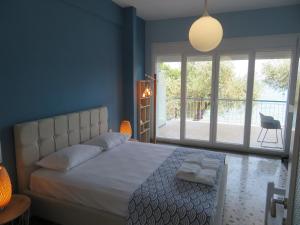 a bedroom with a bed and a large window at RHOMBUS by the sea in Paleo Tsifliki