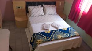 a bedroom with a large bed with white sheets and pillows at Hotel Lado Leste in Sao Paulo