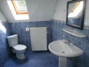 a blue tiled bathroom with a toilet and a sink at Palatinus Apartmanok in Keszthely +56 photos