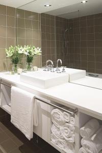 a white sink sitting under a mirror in a bathroom at Mercure Gerringong Resort in Gerringong