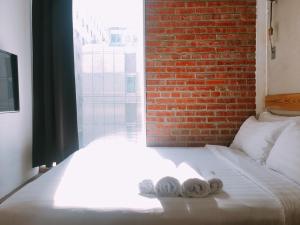 a bed with two towels on it with a brick wall at Just Inn in Taipei