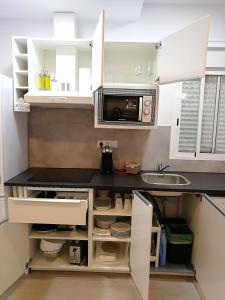 a kitchen with a sink and a microwave at Apartamentos Playa Benitez in Ceuta