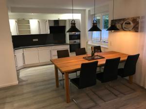 a kitchen and dining room with a wooden table and chairs at VILLA RELAX in Gerolstein