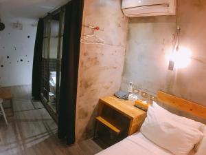 Dormitorio pequeño con cama y espejo en Just Inn 正旅館 北車, en Taipéi