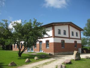 a brick building with a tree in front of it at Ferienwohnungen Ostseestern in Rakow