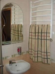 La salle de bains est pourvue d'un lavabo et d'un miroir. dans l'établissement Гостиничные номера и сауна, à Soumy