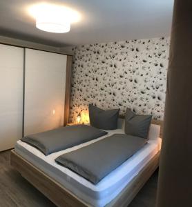 1 dormitorio con 1 cama con pared de flores en VILLA RELAX, en Gerolstein