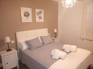 sypialnia z białym łóżkiem i ręcznikami na nim w obiekcie Apartamentos Casa Cipri w mieście Playa Blanca