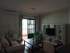 salon z kanapą i telewizorem w obiekcie Apartamentos Casa Cipri w mieście Playa Blanca