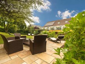 eine Terrasse mit Stühlen, einem Tisch und einem Haus in der Unterkunft Hotel Burgblick in Badenweiler