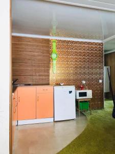 uma cozinha com armários laranja e branco e um frigorífico branco em I love Heviz Apartments em Hévíz
