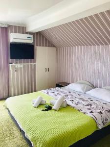 ヘーヴィーズにあるI love Heviz Apartmentsのベッドルーム1室(大型ベッド1台、黄色い毛布付)
