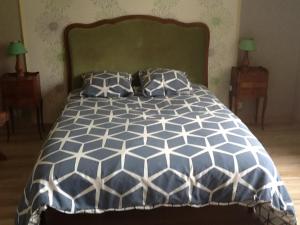 un letto con piumino e cuscini blu e bianchi di Le rocher de bonnevie a Murat