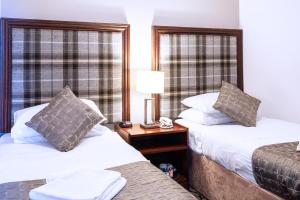 Postel nebo postele na pokoji v ubytování Carrbridge Hotel
