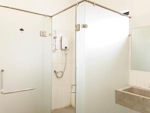 um chuveiro com porta de vidro em um banheiro em HOOD Hostel em Yangon
