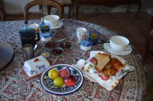 - une table avec petit-déjeuner composé de pain et de fruits dans l'établissement Ellesmere, à Bazens