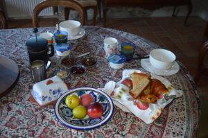 a table with a breakfast of bread and fruit on it at Ellesmere in Bazens