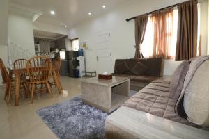 ein Wohnzimmer mit einem Sofa und einem Tisch in der Unterkunft Diyar Villas Puncak H8/7 in Puncak