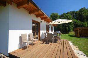 eine Holzterrasse mit Stühlen und einem Sonnenschirm in der Unterkunft chalupa Rejhotice in Loučná nad Desnou