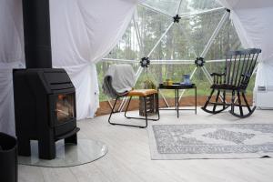 a living room with a fireplace and chairs in a tent at GLØD Aurora Canvas Dome in Alta