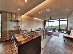 名護的住宿－Condominium NOOSA，一个带水槽的厨房和一间客厅