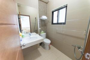 a bathroom with a sink and a toilet and a window at 艷陽天民宿 in Toucheng