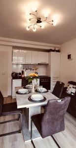 a kitchen with a table with chairs and a dining room at Apartament Comfort Primaverii in Râşnov