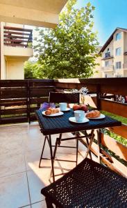 una mesa con 2 platos de comida en el balcón en Apartament Comfort Primaverii en Rîşnov