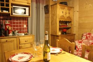 uma garrafa de vinho sentada numa mesa na cozinha em Chalet des pistes em Megève