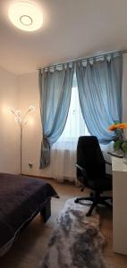 a bedroom with a bed and a chair and a window at Apartament Comfort Primaverii in Râşnov