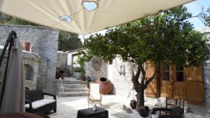 un patio con un árbol y una sombrilla en Arhontiko Frangos, en Kato Drys