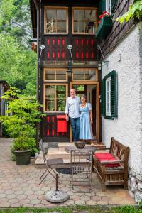 a man and a woman standing outside of a building at B&B Haus Hemetzberger in Hallstatt