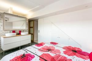a bedroom with a bed with red flowers on it at Luxury Penthouse in Naturiste; FKK, Nudist Village in Cap d'Agde