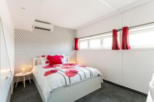 a bedroom with a bed with red pillows and a window at Luxury Penthouse in Naturiste; FKK, Nudist Village in Cap d'Agde