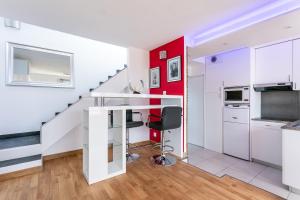 a kitchen with a glass table and a red wall at Luxury Penthouse in Naturiste; FKK, Nudist Village in Cap d'Agde