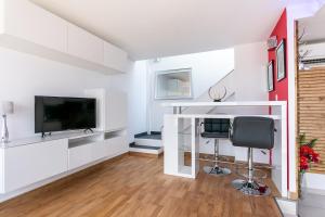 een woonkamer met een televisie en een bureau met een stoel bij Luxury Penthouse in Naturiste; FKK, Nudist Village in Cap d'Agde