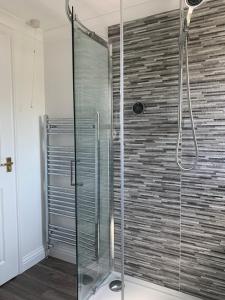 um chuveiro com uma porta de vidro na casa de banho em Thorn House a beautiful large house in Witney em Witney