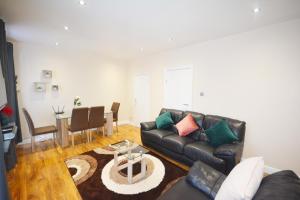 a living room with a couch and a table at London Modern 4 Bedroom Apartment in London