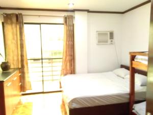 a bedroom with a bed and a large window at Jem Jeff Residence Inn in Cabugao Norte