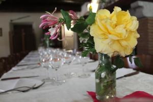 a table with a vase with yellow flowers on it at Biobagnolese Agriturismo in Orte