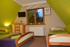 a bedroom with two beds and a window at Willa Otulina pod Giewontem in Zakopane