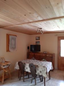 a dining room with a table and a tv at Le Chardon Bleu in Châtel