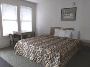 1 dormitorio con cama, mesa y ventana en Beachtree Motel en Galveston