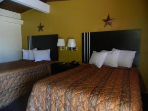 Freer的住宿－Freer Motel，挂在墙上的星星旅馆客房内的两张床