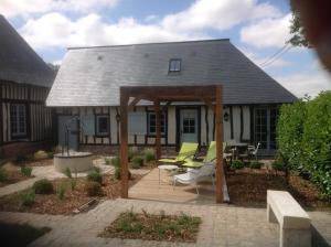 a patio with a gazebo in front of a house at Le Clos-Masure de Béatrice in Montreuil-en-Caux