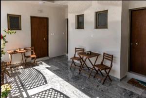 a room with two tables and chairs in a room at Mary's studio in Volos