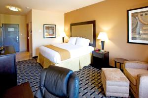 una habitación de hotel con una cama grande y una silla en Holiday Inn Express and Suites Beeville, an IHG Hotel, en Beeville